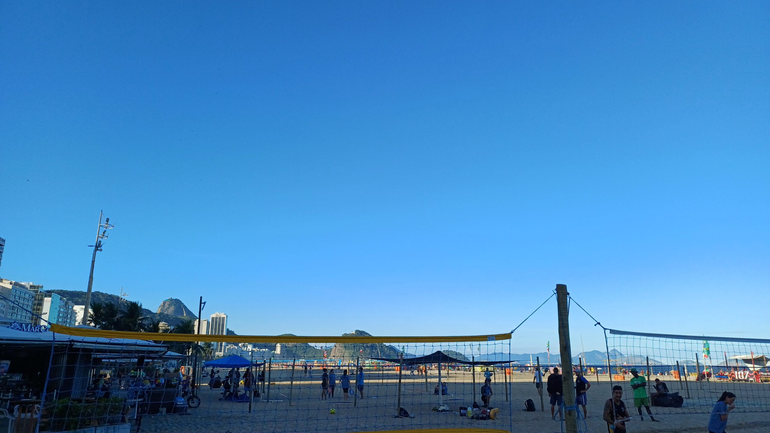 Quadras de vôlei na praia de Copacabana com o Pão de Açúcar ao fundo