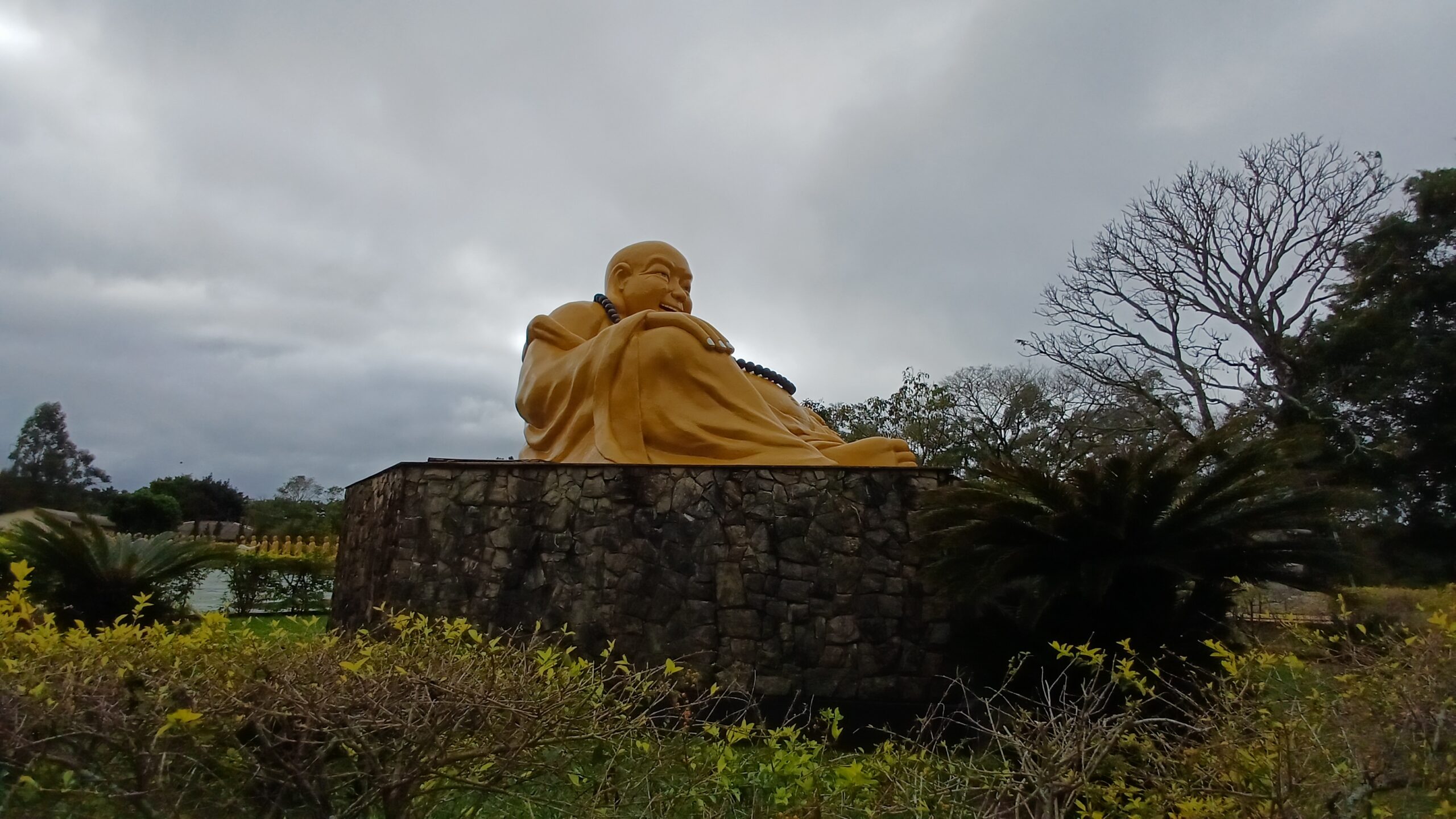 Buda sorridente dourado nos jardins do Templo Budista de Foz do Iguaçu